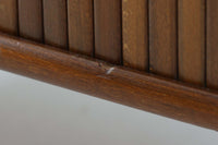 北欧デンマークで製造された、蛇腹扉が特徴的なビンテージキャビネットです。素材にはビーチ材と思われる無垢材や突板が使用されており、ステイン塗装により落ち着いたブラウンカラーに仕上げられています。前面には細かな縦ラインが連続する蛇腹扉が配され、開閉時に滑らかに動く美しい構造が魅力です。内部には棚板が一枚付属しており、収納としての機能性も十分です。丸脚や小さな丸い取っ手も北欧らしい柔らかなディテールで、リビングや玄関、寝室などさまざまな空間に自然に溶け込む一台です。