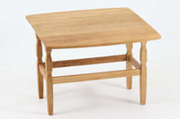 デンマークの建築家Henning Kjaernulf(ヘニング・ケアヌルフ)によってデザインされた、オーク無垢材のドロップリーフ式センターテーブルです。製造は高品質な家具で知られるEGモブラー社。無垢材ならではの美しい木目と、クラシカルで彫刻的な脚部のラインが印象的です。天板は両側に開閉式のリーフが備わっており、来客時や作業時には広げてスペースを拡張できるなど、実用性も兼ね備えています。高さ約51cmとやや高めの設計で、ソファ前に置いても手元が使いやすく、センターテーブルとして快適にお使いいただけます。必要に応じてサイドテーブルやティーテーブルとしても活躍する、用途の広い一台です。