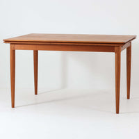 チーク材の温かみある風合いと洗練されたシルエットが魅力のエクステンションダイニングテーブルです。デザイナーは不明ですが、脚部や拡張板の形状など、細部にまでこだわりが感じられる上質な一品です。