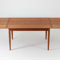 チーク材の温かみある風合いと洗練されたシルエットが魅力のエクステンションダイニングテーブルです。デザイナーは不明ですが、脚部や拡張板の形状など、細部にまでこだわりが感じられる上質な一品です。