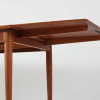 チーク材の温かみある風合いと洗練されたシルエットが魅力のエクステンションダイニングテーブルです。デザイナーは不明ですが、脚部や拡張板の形状など、細部にまでこだわりが感じられる上質な一品です。