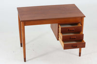 Borge mogensenデザインの小ぶりな片袖デスクは、モーエンセンらしい上質なオーク材が使用された美しいモデルです。デザインの特徴である引き出しの取手も、細部にわたるこだわりが感じられます。本体にはチーク材、脚にはビーチ材が使用され、デンマークの室内靴文化に配慮して、足元には汚れが目立たない濃い色味のチーク材がジョイントされています。洗練されたデザインと実用性を兼ね備えたこのデスクは、どんなインテリアにもマッチするアイテムです。