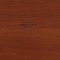 Hans J. Wegnerがデザインし、Andreas Tuck社から発表されたAT33ソーイングテーブルは、チーク無垢材を贅沢に用いた希少なモデルです。両側のバタフライ式天板で作業スペースを拡張でき、仕切り付きの引き出しとラタン製バスケットが裁縫道具や小物を美しく収納します。下段の棚板も備えた実用性の高い構造で、繊細な造作と職人技が光る北欧ビンテージ家具の逸品です。