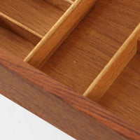 Hans J. Wegnerがデザインし、Andreas Tuck社から発表されたAT33ソーイングテーブルは、チーク無垢材を贅沢に用いた希少なモデルです。両側のバタフライ式天板で作業スペースを拡張でき、仕切り付きの引き出しとラタン製バスケットが裁縫道具や小物を美しく収納します。下段の棚板も備えた実用性の高い構造で、繊細な造作と職人技が光る北欧ビンテージ家具の逸品です。