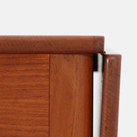 Hans J. Wegnerがデザインし、Andreas Tuck社から発表されたAT33ソーイングテーブルは、チーク無垢材を贅沢に用いた希少なモデルです。両側のバタフライ式天板で作業スペースを拡張でき、仕切り付きの引き出しとラタン製バスケットが裁縫道具や小物を美しく収納します。下段の棚板も備えた実用性の高い構造で、繊細な造作と職人技が光る北欧ビンテージ家具の逸品です。