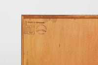 デンマークの家具メーカーHundevad & Co(ハンデバッド)による、Poul Hundevad(ポール・ハンデバッド)デザインのビンテージキャビネットです。美しい木目のチーク材が贅沢に使用され、北欧らしいシンプルで洗練された印象を与えます。両開きの扉内には左側に浅いトレイ状の引き出しが4段、右側には可動棚が2枚設けられており、機能性と収納力に優れた設計。扉の錠前は破損していたため施錠は出来ません。扉の開閉はボールキャッチ方式となっております。鍵は扉開閉用の取っ手として使用します。脚部にはすっきりとしたテーパードレッグが採用され、軽やかで洗練された佇まいが魅力です。リビングやダイニングなど幅広い空間で活躍する一台です。