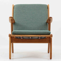 デンマークの国民的ブランドFDBによるビンテージのイージーチェア「J53」。デザイナーは北欧モダンデザインの旗手、Poul M. Volther(ポール・M・ヴォルター)。J53は同氏が手掛けたJシリーズの中でも希少なラウンジチェアタイプで、ゆったりとした座り心地とシンプルな構造美が魅力です。フレームには美しい木目を持つオーク材が使用されており、ナチュラルな風合いが北欧らしい温もりを感じさせます。背面の縦格子デザインや、柔らかくカーブしたアームの形状にも同氏ならではのディテールが感じられます。クッションは新たに張り替え済みで、清潔感のあるグレー系のファブリックが品のある印象を与えます。座面裏FDBのロゴがございます。