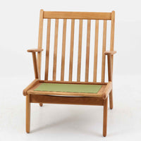 デンマークの国民的ブランドFDBによるビンテージのイージーチェア「J53」。デザイナーは北欧モダンデザインの旗手、Poul M. Volther(ポール・M・ヴォルター)。J53は同氏が手掛けたJシリーズの中でも希少なラウンジチェアタイプで、ゆったりとした座り心地とシンプルな構造美が魅力です。フレームには美しい木目を持つオーク材が使用されており、ナチュラルな風合いが北欧らしい温もりを感じさせます。背面の縦格子デザインや、柔らかくカーブしたアームの形状にも同氏ならではのディテールが感じられます。クッションは新たに張り替え済みで、清潔感のあるグレー系のファブリックが品のある印象を与えます。座面裏FDBのロゴがございます。