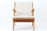 デンマークの国民的ブランドFDBによるビンテージのイージーチェア「J53」。デザイナーは北欧モダンデザインの旗手、Poul m. Volther(ポール・m・ヴォルター)。J53は同氏が手掛けたJシリーズの中でも希少なラウンジチェアタイプで、ゆったりとした座り心地とシンプルな構造美が魅力です。フレームには美しい木目を持つオーク材が使用されており、ナチュラルな風合いが北欧らしい温もりを感じさせます。背面の縦格子デザインや、柔らかくカーブしたアームの形状にも同氏ならではのディテールが感じられます。クッションは新たに張り替え済みで、清潔感のあるアイボリー系のファブリックが品のある印象を与えます。背面に「mADE IN DENmARK」およびFDBの刻印あり。