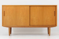 北欧より買い付けたサイドボードです。収納部の右側には、元々レコード収納用として設計されていたと思われる取り外し可能な縦仕切りがあり、幅の調整も可能です。棚板は取り外しできませんが、縦仕切りは全て取り外し可能で、大きなアイテムの収納にも対応できます。左側の収納部には、取り外しや可動が可能な引き出しが2杯備わっており、使い勝手も良好です。シンプルながらも高いクオリティを誇り、デンマークの家具デザイナーPoul Hundevadによってデザインされた本作は、デンマークの厳しい品質基準を満たした「DANISH FURNITUREmAKE'S CONTROL」のロゴシールが付いております。