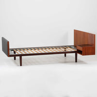 Hans J. Wegnerがデザインし、Getama社によって製造されたこちらのシングルベッドフレームは、チーク材とブラックの合皮パネルが上品に調和した、北欧ビンテージならではの美しい佇まいが魅力です。ヘッドボードにはブラックガラスを載せた引き出し付きのナイトテーブルが備えられていますが、取り外しが可能な構造となっており、空間や用途に応じて柔軟にレイアウトできます。堅牢なスノコ構造で寝具の通気性にも優れ、実用性とデザイン性を兼ね備えた一点です。