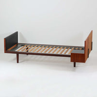 Hans J. Wegnerがデザインし、Getama社によって製造されたこちらのシングルベッドフレームは、チーク材とブラックの合皮パネルが上品に調和した、北欧ビンテージならではの美しい佇まいが魅力です。ヘッドボードにはブラックガラスを載せた引き出し付きのナイトテーブルが備えられていますが、取り外しが可能な構造となっており、空間や用途に応じて柔軟にレイアウトできます。堅牢なスノコ構造で寝具の通気性にも優れ、実用性とデザイン性を兼ね備えた一点です。