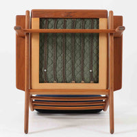 Hans J. Wegnerがデザインし、Getama社によって製造されたGe290Aは、現在では希少となったチーク材のフレームに深いブルーの張地が美しく調和した、ハイバック仕様のビンテージシングルソファです。緩やかに傾斜する背もたれと幅広のアームが身体を包み込むような快適な座り心地を実現し、日常に上質な寛ぎをもたらします。背面の格子状フレームや真鍮ビスなど、細部にまでウェグナーの美意識が宿り、北欧家具の名作としてリビングの主役にふさわしい存在感を放ちます。座面クッションにはスプリングが内包されていますが、背もたれにはウレタンのみが使用されています。