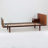 Hans J. Wegnerがデザインし、Getama社によって製造されたこちらのシングルベッドフレームは、チーク材とブラックの合皮パネルが上品に調和した、北欧ビンテージならではの美しい佇まいが魅力です。ヘッドボードにはブラックガラスを載せた引き出し付きのナイトテーブルが備えられていますが、取り外しが可能な構造となっており、空間や用途に応じて柔軟にレイアウトできます。堅牢なスノコ構造で寝具の通気性にも優れ、実用性とデザイン性を兼ね備えた一点です。