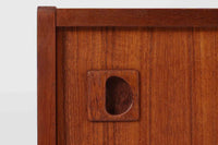 温かみのある木目が美しいチーク材を使用した、北欧ビンテージの小ぶりなローボードです。幅88cmとコンパクトながら、存在感のある佇まいで空間に上品なアクセントを加えます。引き戸の丸みを帯びた掘り込み取っ手や先細りの脚部など、シンプルながらも細部にまでこだわった北欧らしいデザインが魅力です。収納部には棚板が設けられていた形跡がありますが、現在は欠品しております。お気に入りの本や雑貨を飾るディスプレイ用としてもお楽しみいただけます。テレビ台やエントランスの収納など、多用途に活躍してくれる一台です。