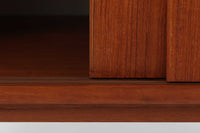 温かみのある木目が美しいチーク材を使用した、北欧ビンテージの小ぶりなローボードです。幅88cmとコンパクトながら、存在感のある佇まいで空間に上品なアクセントを加えます。引き戸の丸みを帯びた掘り込み取っ手や先細りの脚部など、シンプルながらも細部にまでこだわった北欧らしいデザインが魅力です。収納部には棚板が設けられていた形跡がありますが、現在は欠品しております。お気に入りの本や雑貨を飾るディスプレイ用としてもお楽しみいただけます。テレビ台やエントランスの収納など、多用途に活躍してくれる一台です。