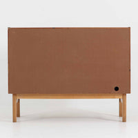 デンマーク製の小ぶりな北欧ビンテージボードで、チーク材とオーク材の組み合わせが上品な一台です。幅90cmとコンパクトながら、引き出し4杯とスライド扉付きの収納部を備え、実用性に優れています。丸いくり抜きの取っ手や直線的な脚部のデザインが軽快な印象を与え、どんな空間にも馴染みやすい造りです。背面の収納部には配線用の穴があり、オーディオや小型テレビ台としても活用可能です。経年により深みを増した木肌が、北欧家具ならではの味わいを感じさせます。