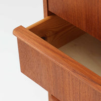 チーク材の美しい木目が前面に現れた、デンマークで作られた4段チェストです。直線を基調とした端正な佇まいと、引き出し上部に取手を設けたミニマルな構造が北欧らしい洗練を感じさせます。脚部は細身で床からの抜け感があり、空間を軽やかに演出します。収納力の高い4段構成で、衣類や書類、小物整理まで幅広く対応し、リビングや寝室、書斎など多様なシーンで活躍します。経年により深みを増したチークの色合いと質感は、ビンテージ家具ならではの魅力です。