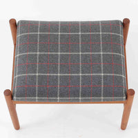 デンマーク製のこちらのスツールは、チーク材の温かみあるフレームに、日本メーカーのチェック柄ファブリックで張り替えを施した、北欧ビンテージ家具らしい洗練と実用性を兼ね備えた一脚です。脚部は丸棒を用いたシンプルな構造で、細部まで丁寧に仕上げられており、軽やかな佇まいの中に確かな安定感が感じられます。張地にはグレーベースに赤のラインがアクセントとなったチェック柄を採用し、空間に個性と落ち着きをもたらします。玄関やベッドサイド、オットマンとしての使用など幅広い用途に対応できるコンパクトなサイズ感も魅力です。また、裏面には「Danish Furnituremakers Control」ラベルが残されており、品質の高さを証明する一品です。経年により深まった木部の風合いと張地のコンビネーションが美しいスツールです。