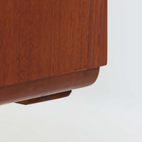 Gunni Omannがデザインし、Omann Jun社によって製造されたModel 18は、洗練されたラインと実用性を兼ね備えた北欧ビンテージの名作サイドボードです。チーク材の美しい木目が前面に広がり、引き出しとスライド扉の組み合わせが高い収納力を実現しています。特に繊細に削り出された取手や先細りの脚部が、軽やかで彫刻的な印象を与え、空間を上質に演出します。幅200cmのサイズ感は、リビングやダイニングの主役として活躍する存在感ある一台です。