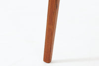 Holger Georg Jensen(ホルガー・ジョージ・イェンセン)によってデザインされ、Kubus moblerから製造されたデンマーク製ビンテージのサイドテーブルです。有機的な曲線を描く天板と、それを支える3本脚の構造が美しいバランスを保っています。天板下には同形状の棚板が設けられており、雑誌や小物の収納にも便利です。素材には艶やかなチーク材が用いられ、天板の木目の美しさも際立っています。北欧モダンを感じさせる上品な佇まいで、ソファサイドやベッドサイドにおすすめの一台です。