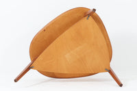 Holger Georg Jensen(ホルガー・ジョージ・イェンセン)によってデザインされ、Kubus moblerから製造されたデンマーク製ビンテージのサイドテーブルです。有機的な曲線を描く天板と、それを支える3本脚の構造が美しいバランスを保っています。天板下には同形状の棚板が設けられており、雑誌や小物の収納にも便利です。素材には艶やかなチーク材が用いられ、天板の木目の美しさも際立っています。北欧モダンを感じさせる上品な佇まいで、ソファサイドやベッドサイドにおすすめの一台です。