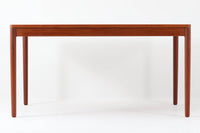 デンマーク製のダイニングテーブル。脚が固定された珍しいデザインで、上質なチーク材を贅沢に使用し、温かみのある色合いと美しい木目が特徴です。シンプルで洗練された細身の脚部は、接合部が特に美しく、北欧家具職人の高い技術が感じられます。装飾を排したミニマルなデザインながら、適度な厚みの天板が重厚感と軽やかさを兼ね備えています。4~6人用のサイズで、ダイニングテーブルとしてはもちろん、書斎デスクやワークテーブルとしても幅広く活用できる、汎用性の高い一品です。