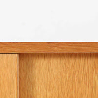 オーク材の美しい木目と柔らかな色味が魅力のこちらのボードは、幅120cmと使い勝手の良いサイズ感で、北欧ビンテージらしい洗練された佇まいが魅力です。内部には可動棚とフェルト付きの浅型引き出しが備えられ、日用品や小物の整理に最適。彫り込み式の取手やテーパードレッグなど、細部にまで配慮された上質な造りが光ります。販売店ラベルとして「Nr. Uttrup Boligmontering」が残されており、当時の流通背景を感じさせる一点物のアイテムです。