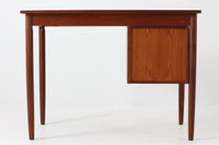 シンプルで洗練された佇まいが魅力のこちらの片袖デスクは、上質なチーク材を用いた北欧ビンテージ家具です。丸みを帯びたテーパードレッグや、緩やかにカーブした引き出しの取っ手が、温もりと職人技を感じさせるディテールとなっています。引き出しは3段構成で収納力があり、鍵付きの上段は大切な書類の保管にも最適です。コンパクトながら実用性に優れており、ワークデスクやドレッサー代わりとしてもおすすめできる逸品です。経年変化による木肌の風合いもビンテージならではの魅力で、空間に落ち着きと品格を与えてくれます。