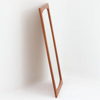 美しい曲線を描いたチーク材のフレームが印象的な壁掛け/立掛けミラーは、北欧ビンテージ家具ならではの優雅さと落ち着いた佇まいを備えています。フレームの内側がわずかに湾曲しており、シンプルなデザインの中にも洗練された個性を感じさせる仕上がりです。軽量で取り扱いやすく、壁に掛けても床に立てかけても絵になる一台。玄関やリビング、寝室のアクセントとして、空間に自然な広がりと明るさをもたらしてく