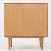 Poul Hundevadがデザインし、Hundevad & Co社から製造されたこちらのキャビネットは、上質なオーク材を用いた小ぶりな北欧ビンテージ品で、すっきりとした面構えと繊細な脚部が印象的な一台です。鍵付きの開き戸を備え、内部には棚板が設けられており、収納家具としての実用性に加え、空間にナチュラルで落ち着いた佇まいをもたらします。なお、脚部は後年に交換されている可能性がありますが、全体の雰囲気を損なわない自然な仕上がりです。