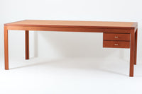 Christian Hvidtがデザインし、Soborg mobler社によって製造されたマホガニー材のデスク。幅200cmのゆとりあるサイズで、シンプルながら洗練されたデザインが魅力です。天板の縁には繊細なディテールが施され、角には美しい組み木のアクセントが加えられています。右側には2杯の引き出しを備え、内部には仕切りもあり、機能性にも優れた設計。マホガニー材ならではの深みのある色合いと、滑らかな木肌が高級感を演出します。シンプルながらも細部にこだわったデザインが、上質な空間を作り出す一台です。