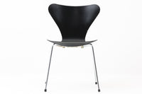 デンマークの名門Fritz Hansen社製、アルネ・ヤコブセンによる名作「セブンチェア」。こちらは2007年に製造された比較的新しいモデルです。成形合板による流れるようなフォルムが特徴で、背もたれから座面へと続く美しいカーブが、快適な座り心地を提供します。ブラックのシェルとクロームメッキの脚がモダンで洗練された印象を演出し、どんな空間にも調和するデザインです。