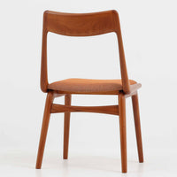 Alfred Christensen(アルフレッド・クリステンセン)によるデザインで、Slagelse Mobelvaerk社から発表されたブーメランチェアです。背から後脚にかけて滑らかに繋がるチーク材の曲線が美しく、丹念な削り出しによる立体的な造形が印象的です。オレンジ系の張地が温かみを添え、北欧らしい明るい雰囲気を演出します。軽やかなフォルムながらしっかりとした安定感があり、ダイニングチェアとしてはもちろん、デスクチェアとしてもお使いいただけます。経年により深みを増した木肌が、ビンテージならではの風格を感じさせる一脚です。