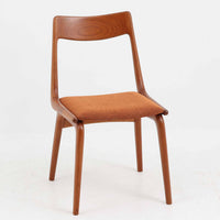 Alfred Christensen(アルフレッド・クリステンセン)によるデザインで、Slagelse Mobelvaerk社から発表されたブーメランチェアです。背から後脚にかけて滑らかに繋がるチーク材の曲線が美しく、丹念な削り出しによる立体的な造形が印象的です。オレンジ系の張地が温かみを添え、北欧らしい明るい雰囲気を演出します。軽やかなフォルムながらしっかりとした安定感があり、ダイニングチェアとしてはもちろん、デスクチェアとしてもお使いいただけます。経年により深みを増した木肌が、ビンテージならではの風格を感じさせる一脚です。