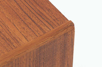 デンマークで製造されたヴィンテージのサイドチェスト。温もりのあるチーク材を用いた本体に、先細りの丸脚を組み合わせた軽やかな佇まいが魅力です。引き出し1杯に加え、下部にはオープンスペースを備えており、リモコンや文庫本などをすぐに取り出せる実用的な構造。天板や側面にはすっきりとした面取りが施され、シンプルなデザインの中に丁寧な仕事が感じられます。北欧らしいあたたかみと実用性を兼ね備えた一台。ベッドサイドはもちろん、リビングや玄関先など、暮らしのさまざまな場面で活躍します。