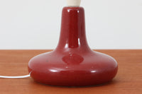 デンマークの照明ブランドLe Klint(レ・クリント)のテーブルランプで、デザイナーはOle Boggild(オーレ・ボギル)。艶やかなレッドの釉薬が美しく、ふっくらと丸みを帯びたフォルムが愛らしくも上品な印象を与えます。シェードはLe Klint社製ではありませんが、新品のリネン製プリーツシェードを合わせており、クラシカルな佇まいと柔らかな光を演出します。北欧らしい温かみと洗練された存在感を持ち、ベッドサイドやリビングのアクセントとして取り入れやすい一灯です。