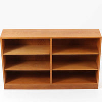 デンマークの名匠Borge MogensenがFDBのためにデザインしたオーク材のブックシェルフは、素朴ながらも洗練された造形と優れた機能性が魅力の北欧ビンテージ家具です。幅122cmのワイドな構成で、可動式の棚板を備えており、本や雑貨の収納に柔軟に対応できます。経年により深みを増したオーク材の風合いが空間に温もりを添え、実用性と美しさを兼ね備えた一台として、リビングや書斎で永くご愛用いただけます。