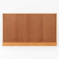 デンマークの名匠Borge MogensenがFDBのためにデザインしたオーク材のブックシェルフは、素朴ながらも洗練された造形と優れた機能性が魅力の北欧ビンテージ家具です。幅122cmのワイドな構成で、可動式の棚板を備えており、本や雑貨の収納に柔軟に対応できます。経年により深みを増したオーク材の風合いが空間に温もりを添え、実用性と美しさを兼ね備えた一台として、リビングや書斎で永くご愛用いただけます。