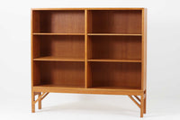 デンマークの名門FDB社より製造された、ボーエ・モーエンセンデザインのヴィンテージブックシェルフ。北欧家具の巨匠であるモーエンセンならではの機能美が際立つ、シンプルかつ実用的なデザインが特徴です。素材には温かみのあるオーク材を使用し、しっかりとした構造と美しい木目が魅力。直線的なフォルムに加え、脚部にはさりげなくデザイン性を加えた補強パーツが施され、安定感と視覚的な軽やかさを両立しています。広々とした収納スペースは書籍や雑貨の収納に最適で、シンプルながらも存在感のあるデザインはリビングや書斎、寝室など幅広い空間に調和します。FDB社のクラフトマンシップが息づく、北欧ヴィンテージの逸品をお楽しみください。脚はビンテージのオリジナル品です。