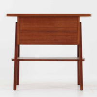 チーク材を用いたこちらの2段チェストは、緩やかにカーブした天板と舟形の引き手が特徴的な北欧ビンテージ家具です。幅64cmとコンパクトながらも引き出し2杯と下部の棚板を備え、収納力とディスプレイ性を兼ね備えています。テーパー脚が軽やかな印象を与え、ベッドサイドやリビングのサイドテーブルとしても活躍。年月を経た木肌の温かみが、空間に落ち着きと味わい深い存在感をもたらす一品です。