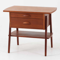 チーク材を用いたこちらの2段チェストは、緩やかにカーブした天板と舟形の引き手が特徴的な北欧ビンテージ家具です。幅64cmとコンパクトながらも引き出し2杯と下部の棚板を備え、収納力とディスプレイ性を兼ね備えています。テーパー脚が軽やかな印象を与え、ベッドサイドやリビングのサイドテーブルとしても活躍。年月を経た木肌の温かみが、空間に落ち着きと味わい深い存在感をもたらす一品です。