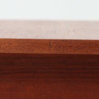 チーク材を用いたこちらの2段チェストは、緩やかにカーブした天板と舟形の引き手が特徴的な北欧ビンテージ家具です。幅64cmとコンパクトながらも引き出し2杯と下部の棚板を備え、収納力とディスプレイ性を兼ね備えています。テーパー脚が軽やかな印象を与え、ベッドサイドやリビングのサイドテーブルとしても活躍。年月を経た木肌の温かみが、空間に落ち着きと味わい深い存在感をもたらす一品です。