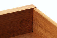 デンマークを代表する家具デザイナー、Hans J. Wegner(ハンス・J・ウェグナー)によってデザインされた、Ry mobler社製のビンテージサイドテーブルです。素材にはあたたかみのあるオーク材が用いられており、北欧らしいシンプルかつ機能的な美しさが感じられます。天板は縁に立ち上がりがあり、物が転がり落ちにくい仕様。引き出しとオープンスペースが組み合わされた実用的な構造で、ベッドサイドやソファ横、玄関周りなど様々なシーンで活躍します。無駄のないデザインと丸脚の柔らかな佇まいが魅力で、ウェグナーデザインならではのバランス感が光る一台です。