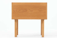 デンマークを代表する家具デザイナー、Hans J. Wegner(ハンス・J・ウェグナー)によってデザインされた、Ry mobler社製のビンテージサイドテーブルです。素材にはあたたかみのあるオーク材が用いられており、北欧らしいシンプルかつ機能的な美しさが感じられます。天板は縁に立ち上がりがあり、物が転がり落ちにくい仕様。引き出しとオープンスペースが組み合わされた実用的な構造で、ベッドサイドやソファ横、玄関周りなど様々なシーンで活躍します。無駄のないデザインと丸脚の柔らかな佇まいが魅力で、ウェグナーデザインならではのバランス感が光る一台です。