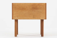 デンマークを代表する家具デザイナー、Hans J. Wegner(ハンス・J・ウェグナー)によってデザインされた、Ry mobler社製のビンテージサイドテーブルです。素材にはあたたかみのあるオーク材が使用されており、北欧らしいシンプルで機能的な美しさが感じられます。天板には縁に立ち上がりが設けられており、小物が転がり落ちにくい実用的な仕様。引き出しとオープンスペースが組み合わされたデザインで、ベッドサイドやソファ横、玄関周りなど様々なシーンで活躍します。無駄のないフォルムと丸脚の柔らかな佇まいが魅力で、ウェグナーデザインならではの美しいバランスが光る一台です。背板には、同モデルとしては珍しくオーク材ではなくmDFと思われる素材が使用されています。また、天板には目立つ傷がございますため、その点を考慮した価格設定とさせていただいております。