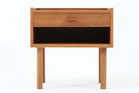 デンマークを代表する家具デザイナー、Hans J. Wegner(ハンス・J・ウェグナー)によってデザインされた、Ry mobler社製のビンテージサイドテーブルです。素材にはあたたかみのあるオーク材が使用されており、北欧らしいシンプルで機能的な美しさが感じられます。天板には縁に立ち上がりが設けられており、小物が転がり落ちにくい実用的な仕様。引き出しとオープンスペースが組み合わされたデザインで、ベッドサイドやソファ横、玄関周りなど様々なシーンで活躍します。無駄のないフォルムと丸脚の柔らかな佇まいが魅力で、ウェグナーデザインならではの美しいバランスが光る一台です。背板には、同モデルとしては珍しくオーク材ではなくmDFと思われる素材が使用されています。また、天板には目立つ傷がございますため、その点を考慮した価格設定とさせていただいております。