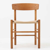 デンマークを代表するデザイナー、Borge MogensenによってFDBのためにデザインされたJ39チェアは、オーク材の丸脚と座面に丁寧に編み込まれたペーパーコードが特徴の、素朴ながらも完成度の高い北欧ビンテージチェアです。農村のキッチンチェアをルーツに持つそのデザインは、無駄を省いた潔い構造と機能美が融合し、空間に凛とした佇まいをもたらします。ダイニングはもちろん、ワークチェアやアクセントチェアとしても重宝する一脚です。