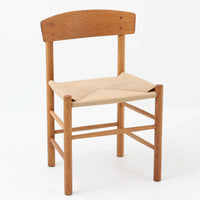 デンマークを代表するデザイナー、Borge MogensenによってFDBのためにデザインされたJ39チェアは、オーク材の丸脚と座面に丁寧に編み込まれたペーパーコードが特徴の、素朴ながらも完成度の高い北欧ビンテージチェアです。農村のキッチンチェアをルーツに持つそのデザインは、無駄を省いた潔い構造と機能美が融合し、空間に凛とした佇まいをもたらします。ダイニングはもちろん、ワークチェアやアクセントチェアとしても重宝する一脚です。