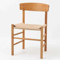 デンマークを代表するデザイナー、Borge MogensenによってFDBのためにデザインされたJ39チェアは、オーク材の丸脚と座面に丁寧に編み込まれたペーパーコードが特徴の、素朴ながらも完成度の高い北欧ビンテージチェアです。農村のキッチンチェアをルーツに持つそのデザインは、無駄を省いた潔い構造と機能美が融合し、空間に凛とした佇まいをもたらします。ダイニングはもちろん、ワークチェアやアクセントチェアとしても重宝する一脚です。